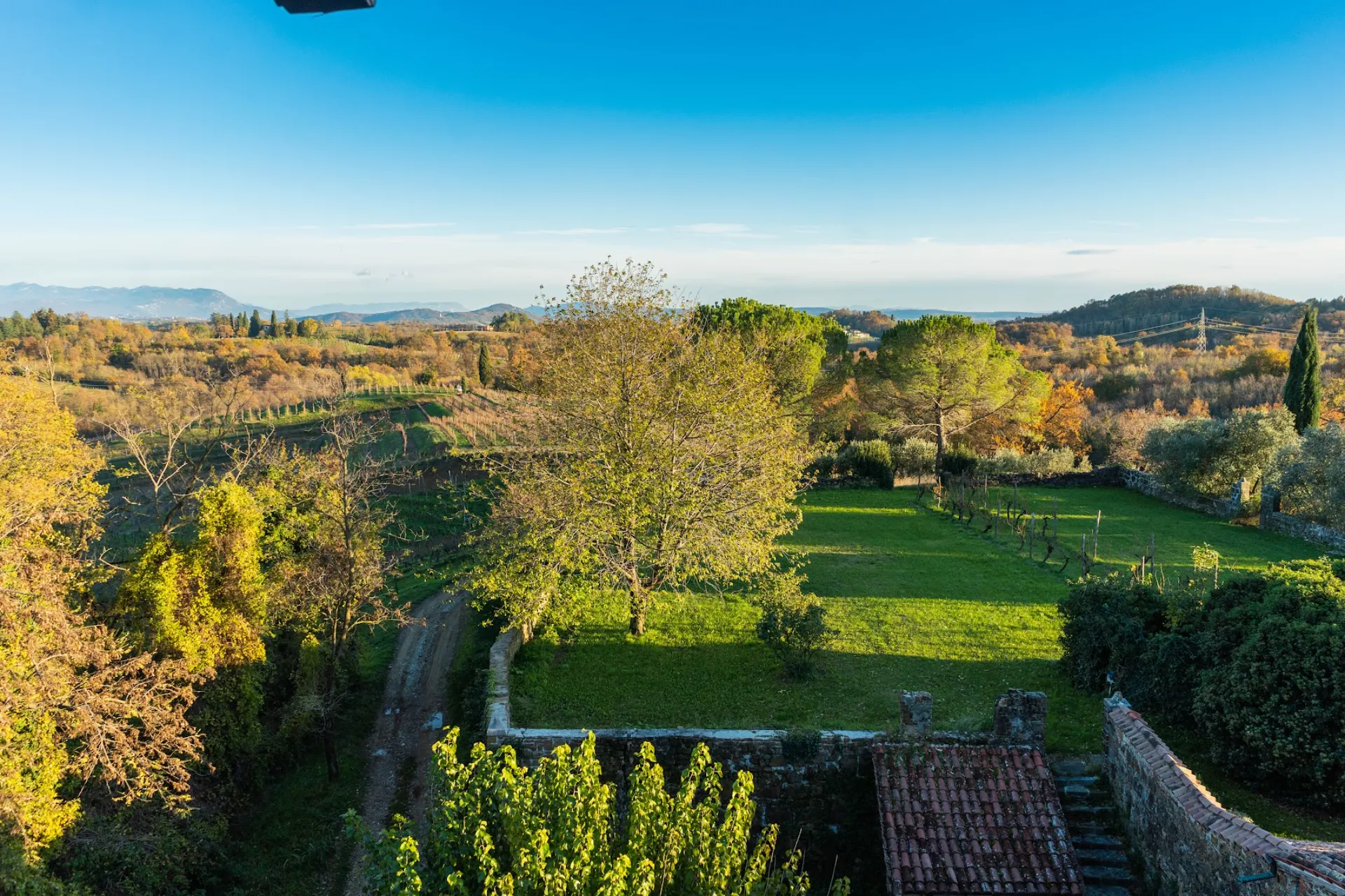 Splendid hilly panorama with meadows and trees in autumn colors surrounding Villa Ottelio