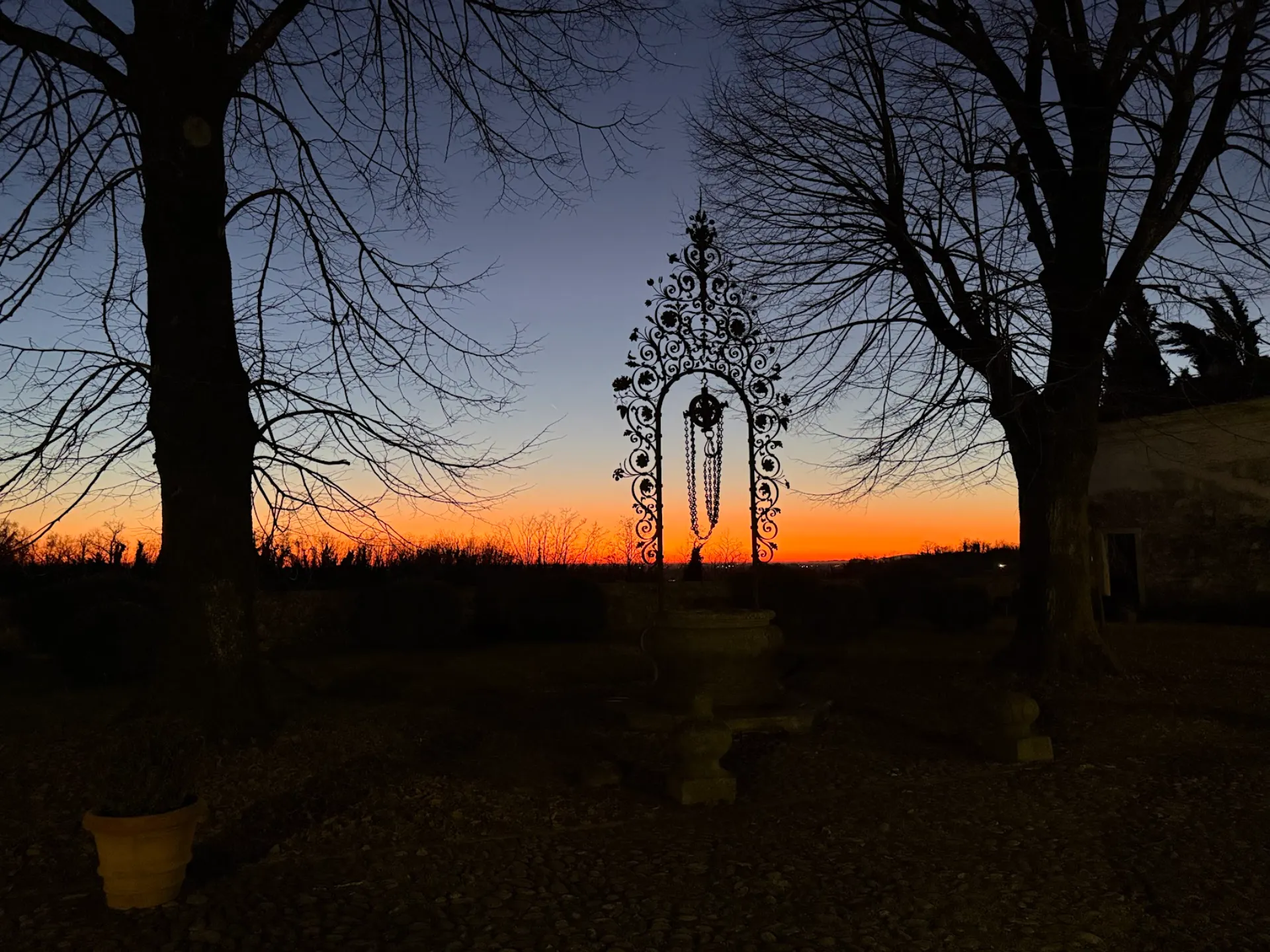 Historic wrought iron well of Villa Ottelio de Carvalho at sunset, symbol of timeless investment